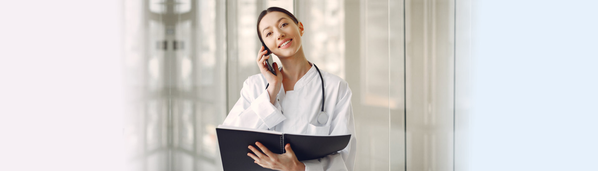 a female doctor answering phone and smiling